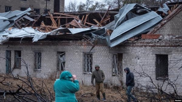 FILE - Residents walk at a site of a Russian missile strike in Dnipro, Nov. 21, 2025.