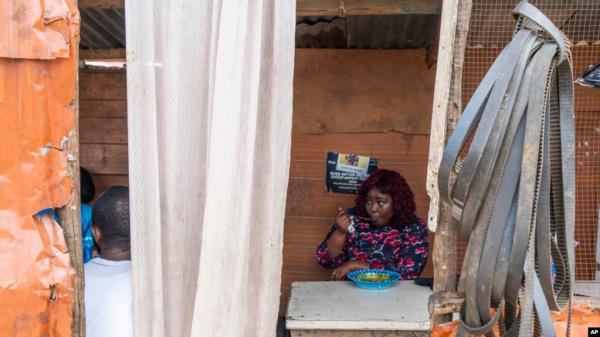 FILE - Anima Mangola eats rice and stewed cassava leaves in the Sierra Leone capital, Freetown, Sept. 25, 2024. 